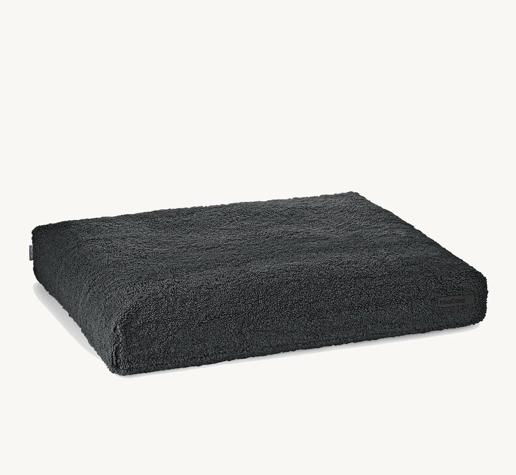 Coussin Senso MiaCara en bouclé coloris graphite sur fond neutre – Maison Canisya