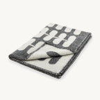 Flora – couverture en laine pliée, motif floral anthracite et naturel – Maison Canisya