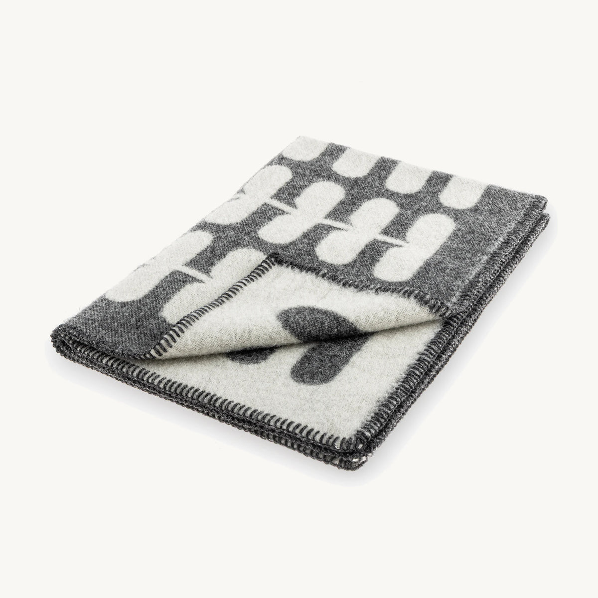 Flora – couverture en laine pliée, motif floral anthracite et naturel – Maison Canisya