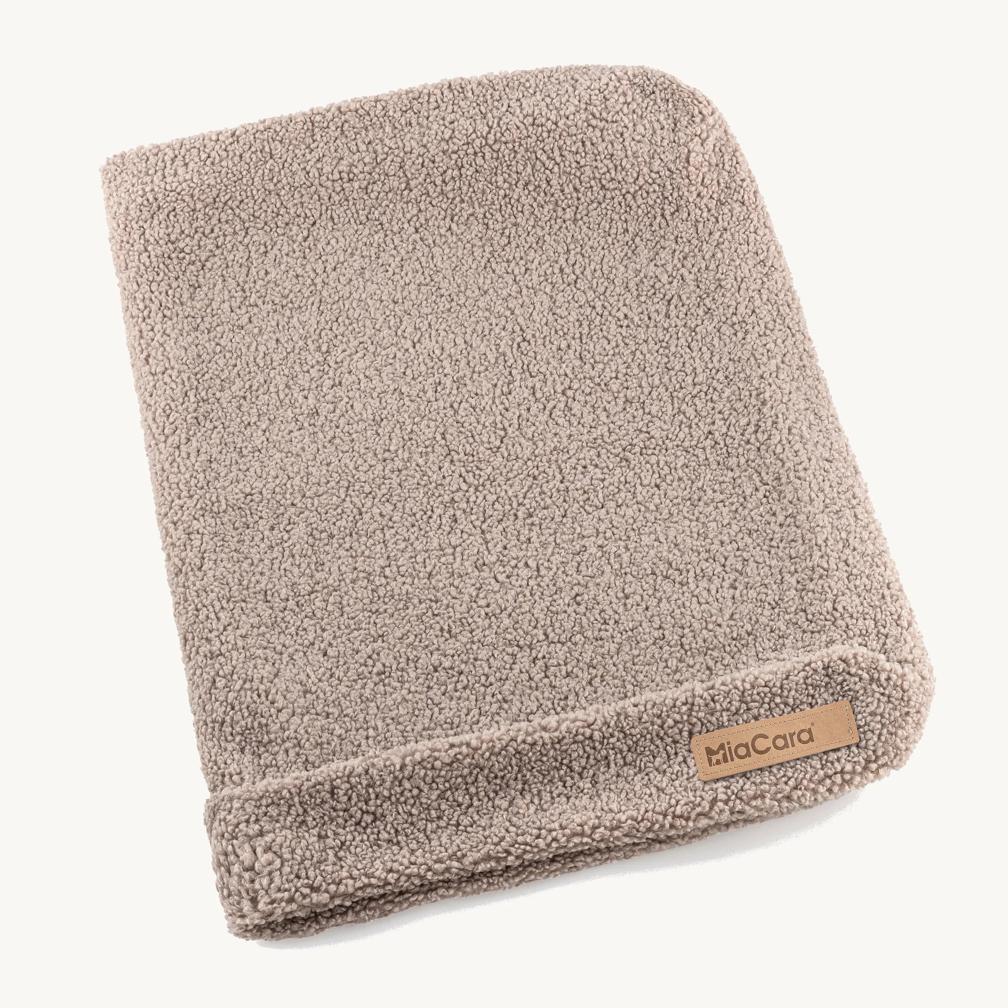 Housse de coussin Senso MiaCara en tissu bouclé coloris greige, posée à plat sur fond neutre — Maison Canisya