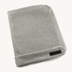 Housse de coussin Senso MiaCara en tissu bouclé coloris pebble, posée à plat sur fond neutre — Maison Canisya