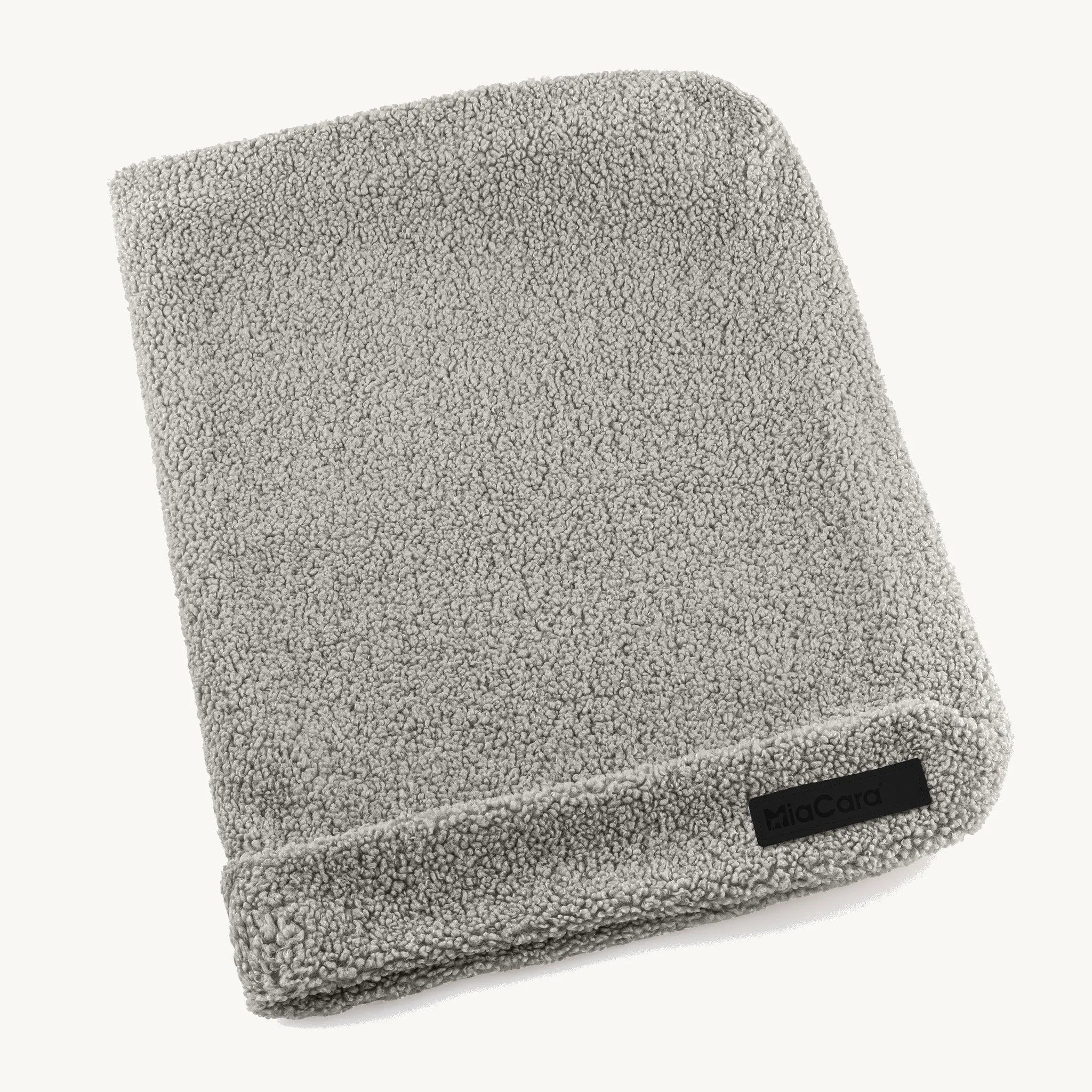 Housse de coussin Senso MiaCara en tissu bouclé coloris pebble, posée à plat sur fond neutre — Maison Canisya
